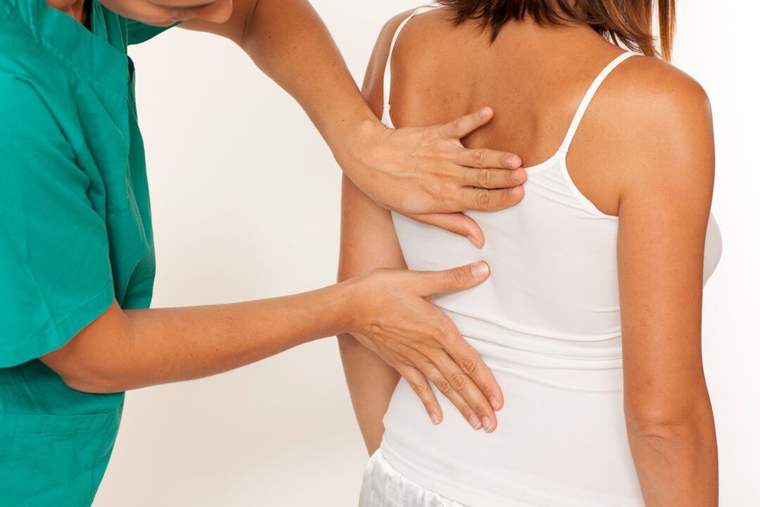 a doctor examines the back for pain in the shoulder blades